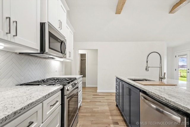 6512 N 27th St, Broken Arrow, OK 74014 - kitchen with stainless steel appliances, white cabinetry, tasteful backsplash, light wood-style flooring, and light stone counters