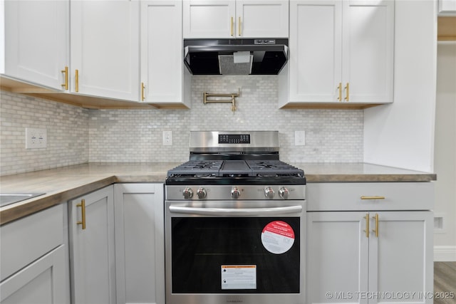 4526 W Broadway St, Muskogee, OK 74401 - kitchen featuring stainless steel gas range, extractor fan, white cabinetry, and decorative backsplash