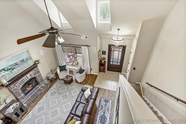 14355 N Trenton Ave, Skiatook, OK 74070 - foyer entrance featuring wood finished floors, high vaulted ceiling, a fireplace, ceiling fan, and a chandelier