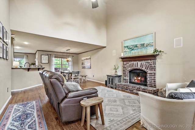 14355 N Trenton Ave, Skiatook, OK 74070 - living area with wood finished floors, a fireplace, ceiling fan, and a towering ceiling