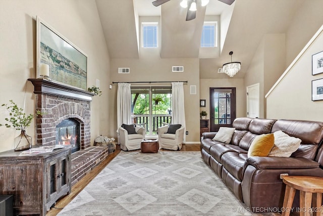 14355 N Trenton Ave, Skiatook, OK 74070 - living room with high vaulted ceiling, a ceiling fan, a brick fireplace, and wood finished floors