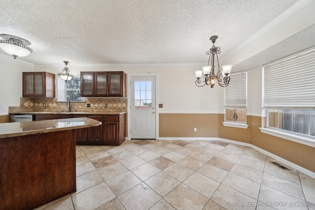 9227 S 95th E Ave, Tulsa, OK 74133 - kitchen featuring a textured ceiling, a chandelier, decorative backsplash, pendant lighting, and glass insert cabinets