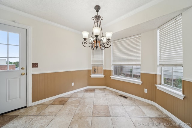 9227 S 95th E Ave, Tulsa, OK 74133 - unfurnished dining area with wainscoting, a chandelier, crown molding, a textured ceiling, and baseboards