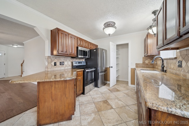 9227 S 95th E Ave, Tulsa, OK 74133 - kitchen with appliances with stainless steel finishes, a sink, a peninsula, decorative backsplash, and ornamental molding