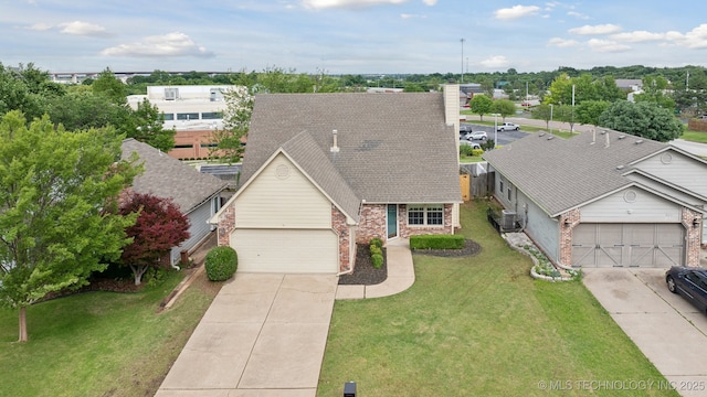 9227 S 95th E Ave, Tulsa, OK 74133 - view of front facade with brick siding, concrete driveway, roof with shingles, and a front yard