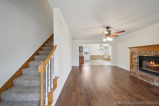9227 S 95th E Ave, Tulsa, OK 74133 - unfurnished living room with stairs, ceiling fan, a fireplace, a chandelier, and dark wood finished floors