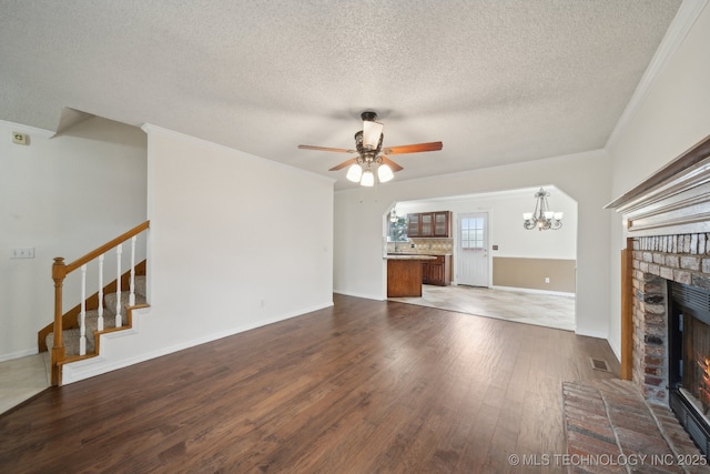 9227 S 95th E Ave, Tulsa, OK 74133 - unfurnished living room featuring a brick fireplace, crown molding, a chandelier, ceiling fan, and wood finished floors