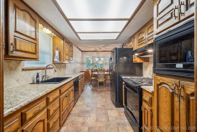 2630 W Boston Pl, Broken Arrow, OK 74012 - kitchen with black appliances, under cabinet range hood, a sink, stone finish flooring, and brown cabinetry