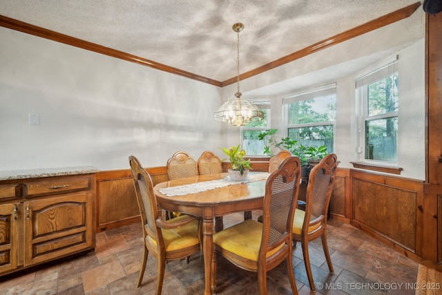 2630 W Boston Pl, Broken Arrow, OK 74012 - dining area featuring stone tile floors, crown molding, a textured ceiling, a chandelier, and wainscoting