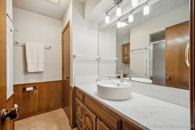 2630 W Boston Pl, Broken Arrow, OK 74012 - full bathroom featuring vanity, a stall shower, wainscoting, wood walls, and a textured ceiling