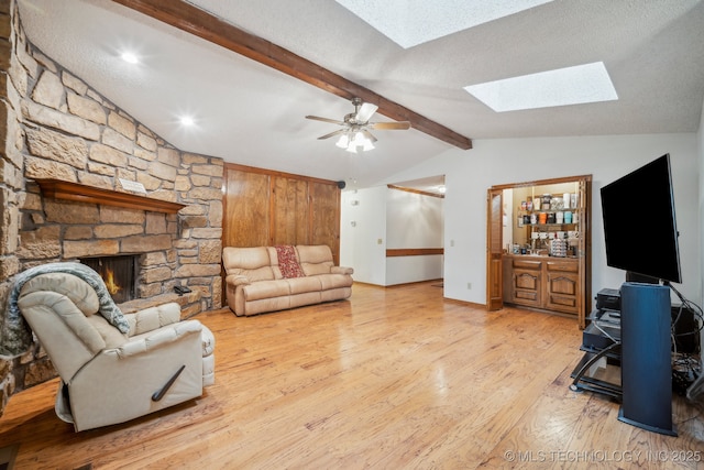 2630 W Boston Pl, Broken Arrow, OK 74012 - living area with a skylight, wood finished floors, ceiling fan, a stone fireplace, and baseboards