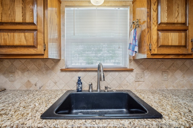 2630 W Boston Pl, Broken Arrow, OK 74012 - kitchen featuring a sink, brown cabinetry, and tasteful backsplash