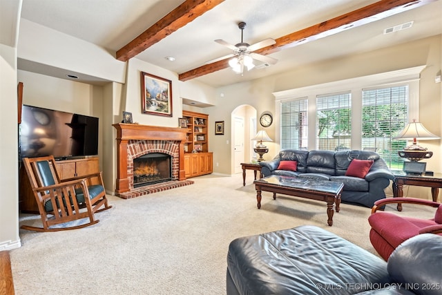 11715 S 93rd E Ave, Bixby, OK 74008 - living area featuring arched walkways, beam ceiling, a ceiling fan, a fireplace, and carpet floors