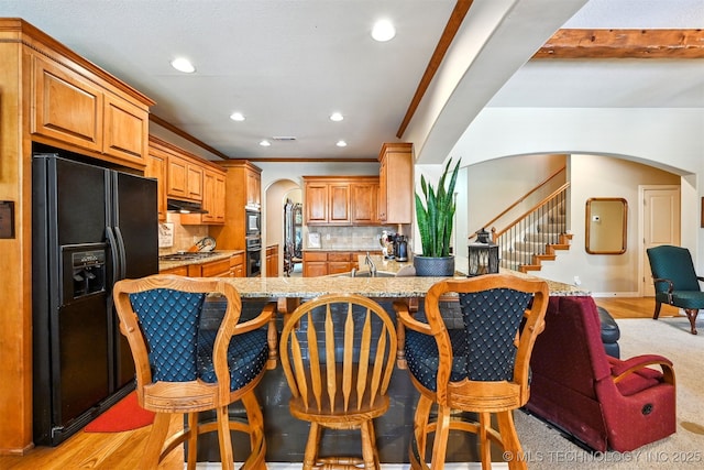 11715 S 93rd E Ave, Bixby, OK 74008 - kitchen with black appliances, arched walkways, recessed lighting, under cabinet range hood, and backsplash
