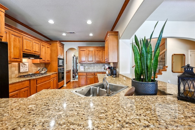 11715 S 93rd E Ave, Bixby, OK 74008 - kitchen with arched walkways, black appliances, under cabinet range hood, recessed lighting, and light wood-style floors