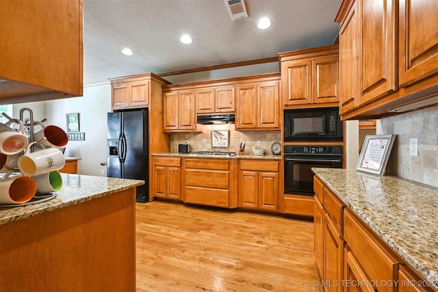 11715 S 93rd E Ave, Bixby, OK 74008 - kitchen with black appliances, under cabinet range hood, brown cabinets, recessed lighting, and light stone countertops