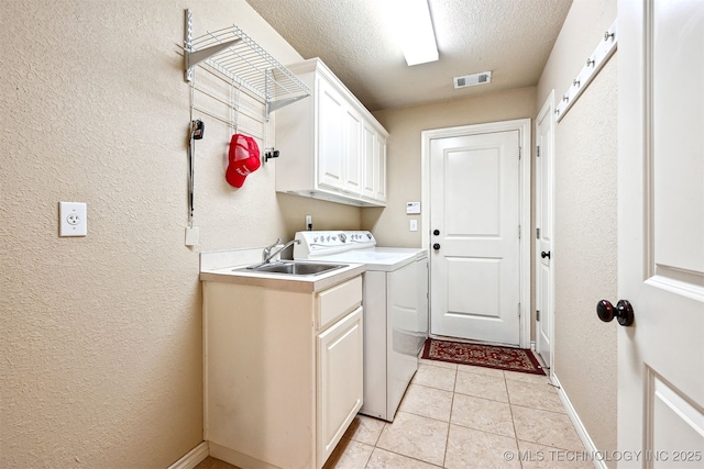 11715 S 93rd E Ave, Bixby, OK 74008 - laundry room with cabinet space, a textured wall, light tile patterned floors, a textured ceiling, and washer and clothes dryer