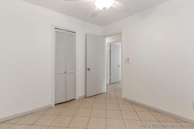 349 S 185th E Ave, Tulsa, OK 74108 - unfurnished bedroom featuring a closet, baseboards, ceiling fan, and light tile patterned floors