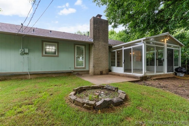 349 S 185th E Ave, Tulsa, OK 74108 - rear view of house featuring a sunroom, a chimney, roof with shingles, a lawn, and a patio
