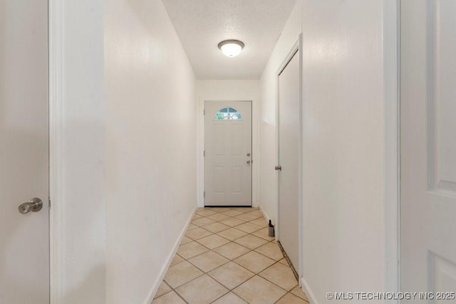 349 S 185th E Ave, Tulsa, OK 74108 - hallway featuring baseboards, light tile patterned flooring, and a textured ceiling