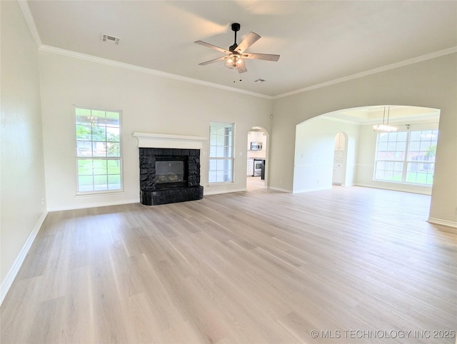 7870 N 163rd E Ct, Owasso, OK 74055 - unfurnished living room featuring a ceiling fan, ornamental molding, light wood-style flooring, healthy amount of natural light, and arched walkways
