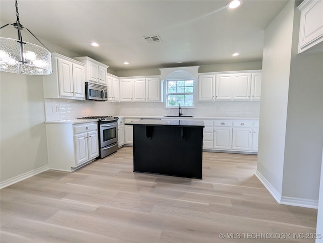 7870 N 163rd E Ct, Owasso, OK 74055 - kitchen with appliances with stainless steel finishes, white cabinetry, decorative backsplash, a sink, and light countertops