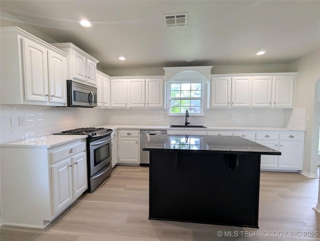 7870 N 163rd E Ct, Owasso, OK 74055 - kitchen with stainless steel appliances, a sink, light wood-type flooring, white cabinetry, and recessed lighting