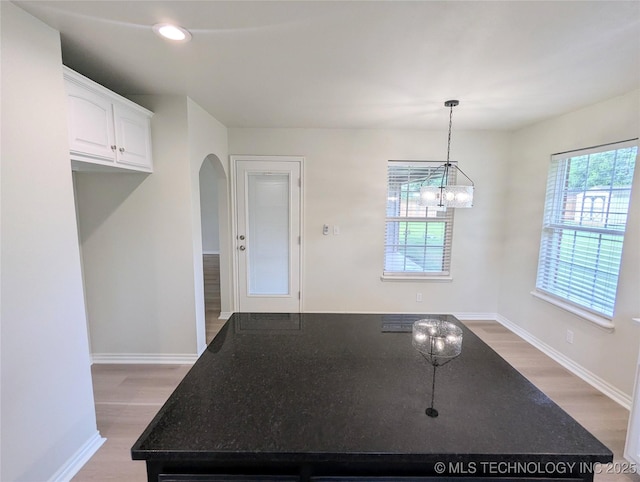 7870 N 163rd E Ct, Owasso, OK 74055 - kitchen with arched walkways, light wood-type flooring, dark stone countertops, white cabinets, and recessed lighting