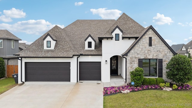 602 E 130th St S, Jenks, OK 74037 - french country inspired facade featuring a shingled roof, driveway, a front lawn, stucco siding, and stone siding