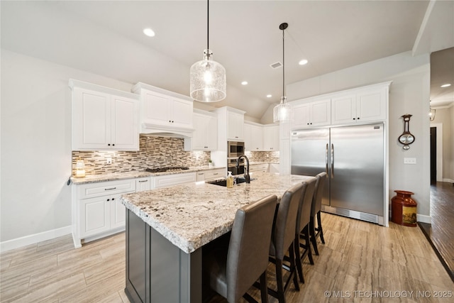 602 E 130th St S, Jenks, OK 74037 - kitchen with built in appliances, tasteful backsplash, vaulted ceiling, light wood finished floors, and white cabinetry