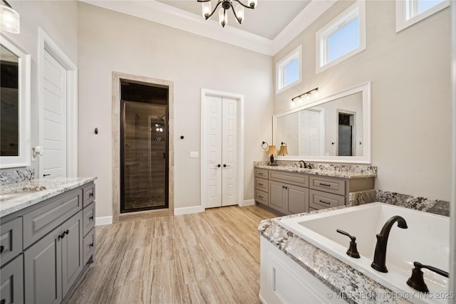 602 E 130th St S, Jenks, OK 74037 - bathroom featuring two vanities, a bath, a stall shower, and a chandelier