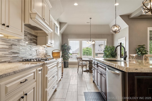 12934 S 2nd St, Jenks, OK 74037 - kitchen with appliances with stainless steel finishes, a sink, a chandelier, decorative backsplash, and light stone counters