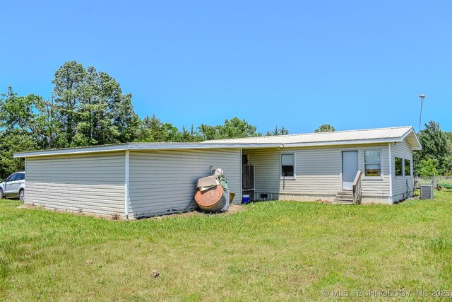 919 N 4210th Rd, Hugo, OK 74743 - rear view of house featuring entry steps, a lawn, and central AC