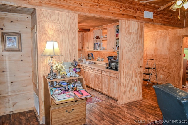 919 N 4210th Rd, Hugo, OK 74743 - kitchen featuring dark wood-type flooring, light brown cabinetry, ceiling fan, wooden walls, and light countertops