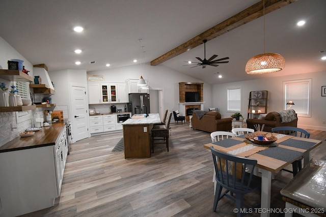 20471 W Chicken Creek Rd, Cookson, OK 74427 - dining space featuring wood finished floors, a fireplace, ceiling fan, and recessed lighting