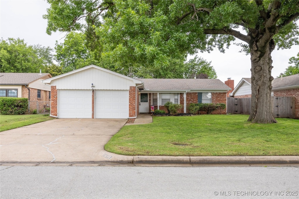 6927 E 17th St, Tulsa, OK 74112 - single story home with brick siding, concrete driveway, and an attached garage