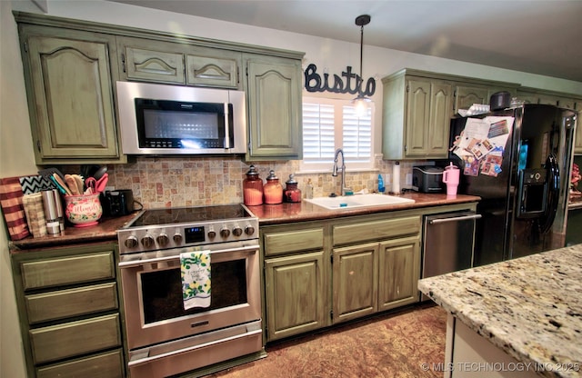 2430 S 31st St E, Muskogee, OK 74403 - kitchen featuring stainless steel appliances, a sink, decorative backsplash, and hanging light fixtures
