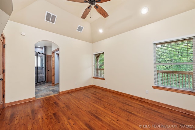 5687 Lake Jackson Rd, Mounds, OK 74047 - spare room with arched walkways, plenty of natural light, vaulted ceiling, a ceiling fan, and wood finished floors