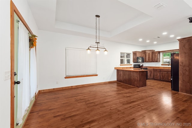 5687 Lake Jackson Rd, Mounds, OK 74047 - kitchen featuring black appliances, a peninsula, wood finished floors, a tray ceiling, and recessed lighting