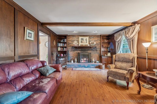 6506 E 99th St, Tulsa, OK 74133 - living room featuring wood finished floors, a brick fireplace, beamed ceiling, and built in shelves