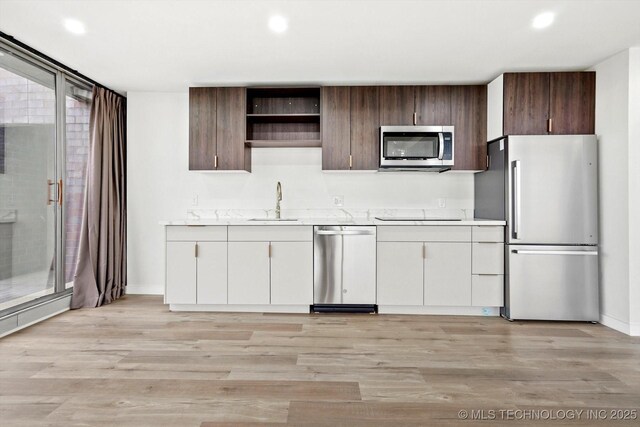5810 E Skelly Dr Unit 303, Tulsa, OK 74135 - kitchen with stainless steel appliances, light countertops, a sink, baseboards, and recessed lighting