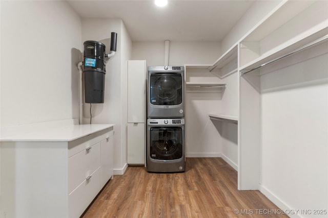 14382 Adams Rd, Mounds, OK 74047 - washroom with stacked washer / dryer, cabinet space, and light wood finished floors
