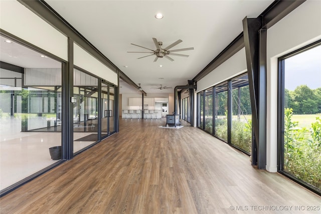 14382 Adams Rd, Mounds, OK 74047 - unfurnished sunroom with wood finished floors, a wood stove, and recessed lighting