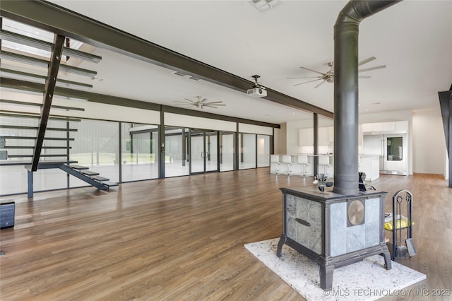 14382 Adams Rd, Mounds, OK 74047 - living room with a wood stove, a ceiling fan, and wood finished floors