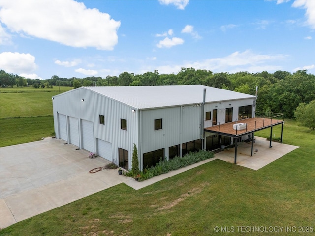 14382 Adams Rd, Mounds, OK 74047 - back of house featuring a lawn, a detached garage, an outdoor structure, and a metal roof