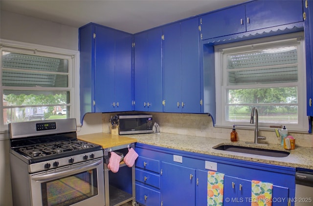 806 S New Haven Ave, Tulsa, OK 74112 - kitchen with appliances with stainless steel finishes, a sink, backsplash, and blue cabinetry