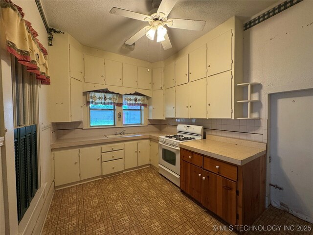 1524 W Maple St W, Durant, OK 74701 - kitchen with gas range gas stove, light countertops, a sink, open shelves, and light flooring