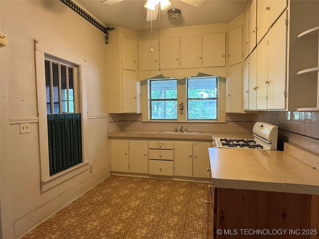 1524 W Maple St W, Durant, OK 74701 - kitchen with white range with gas stovetop, a ceiling fan, a sink, light countertops, and open shelves