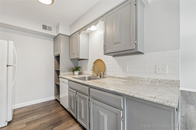 4440 68th St Unit 486, Tulsa, OK 74136 - kitchen with gray cabinetry, white appliances, a sink, dark wood-style floors, and backsplash