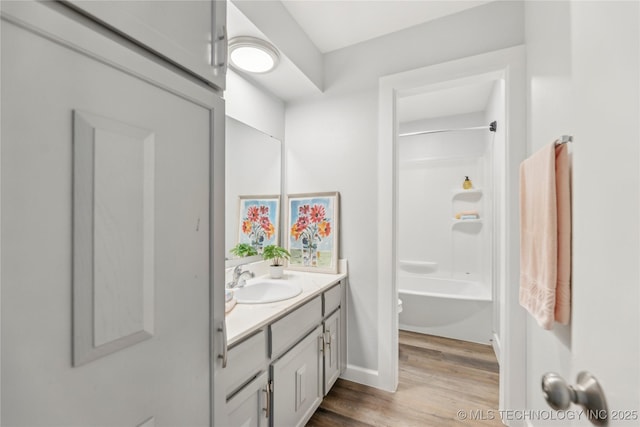 4440 68th St Unit 486, Tulsa, OK 74136 - full bathroom featuring vanity, wood finished floors, tub / shower combination, and baseboards